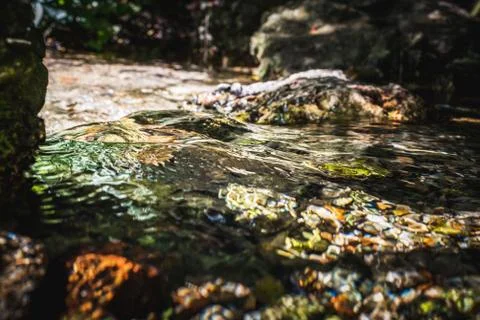 Stream of natural water source at its starting point among the rocks Stock Photos