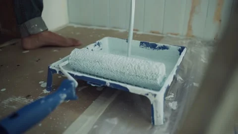 A stream of paint pours into the tray. A bath for painting with a roller. Roller Stock Footage 157263782