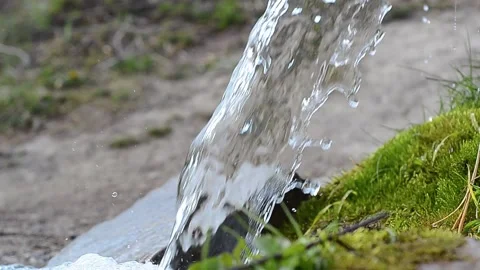 Stream of pure water flowing on a background of green moss. Stock Footage 130321911