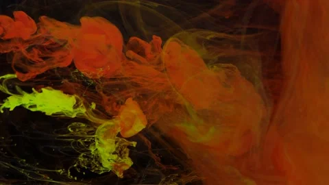 Stream of red and yellow paint dissolves in a transparent space on a black Stock Footage 211470813
