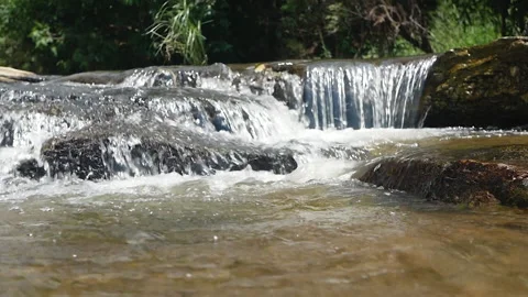 Stream running fast on stones covered with moss in national park.Small waterfall Video stock 138907104