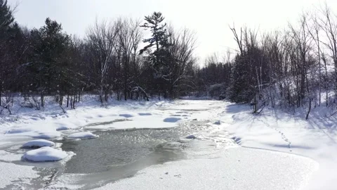 Stream running through forest covered in snow low flight beauty. Stock Footage 150270216