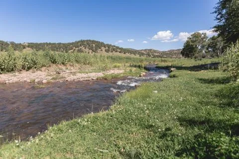 Stream running through meadows and mountain range on a ranch Stock Photos