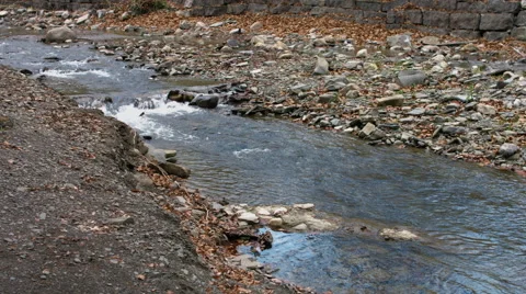 Stream running through rocky shore Stock Footage 63311073