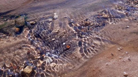 A stream on the sand. The flow of the creek, the flow of water on the ground. Stock Footage 288477339
