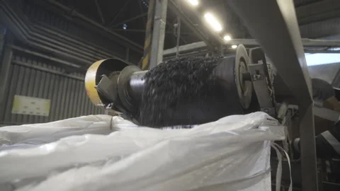 Stream of shredded rubber drops into metallic container Stock Footage 314642597