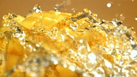 A stream of splashed water pours onto fresh mangoes. Filmed on a high-speed Video stock 263283656