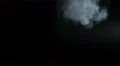 The stream of thick smoke on a dark background. Slow motion capture 4k or 4k+ Resolution