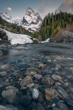 A stream in the valley surrounded by mountains in winter Stock Photos