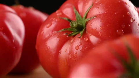 A stream of water and splashes fall on a red juicy tomato. Close-up. Vídeo Stock 271196451
