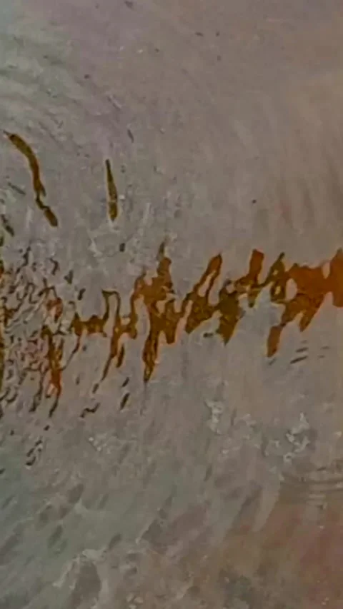 A stream of water on the cement floor creating reddish-brown color reflections. 스톡 동영상 346865778