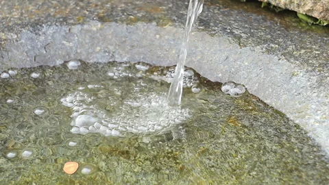 Stream of water dropping into the small stone bowl and water bubbling Stock Footage 103661094