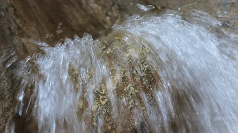 Stream of water drops against the stone creating a sprays Stock Footage 125448025