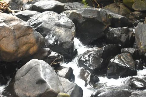 A stream of water falling between the rocks Stock Photos