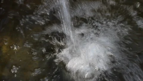 The stream of water falling in dark pool Stock Footage 8828330