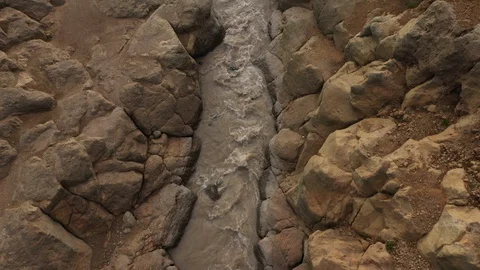A Stream Of Water Falling Into a Deep Gorge, Canyon. Drone Video. Aerial View Stock Footage 128660521