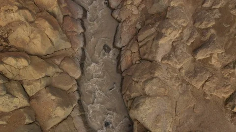 A Stream Of Water Falling Into a Deep Gorge, Canyon. Drone Video. Aerial View Stock Footage 128661676