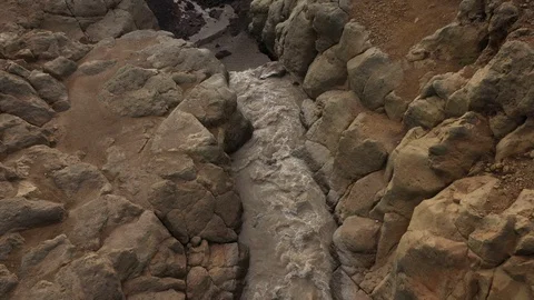 A Stream Of Water Falling Into a Deep Gorge, Canyon. Drone Video. Aerial View Stock Footage 128670311