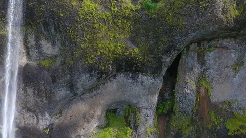 A stream of water falls along a stone wall with caves in the mountain. Andreev. Stock Footage 78510256