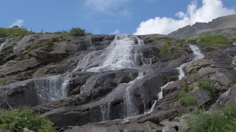 Stream of water falls and flows down rocky slope Stock Footage 145889496