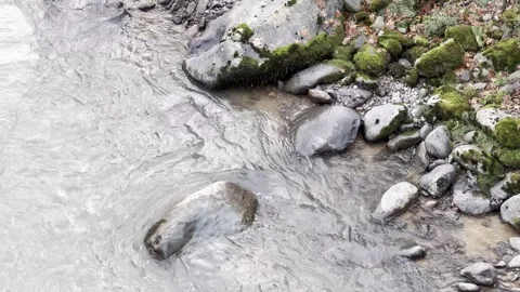 A stream of water is flowing between rocks Stock Footage 296182977
