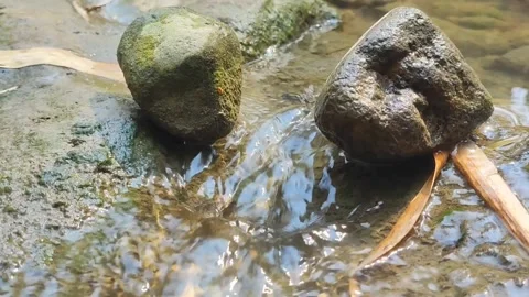 Stream Water Flowing Between Two River Stones Close-up Stock Footage 346607420