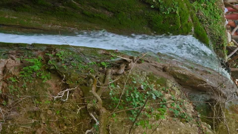 A stream of water is flowing down a rocky hillside Stock Footage 273388041