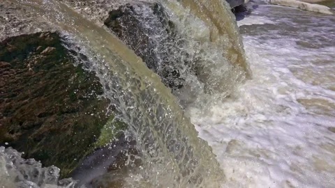 Stream of water flowing down small waterfall into bubbly creek Stock Footage 142401077