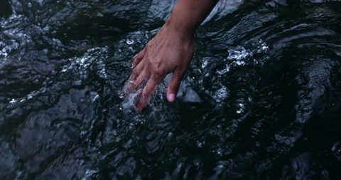 Stream water flowing on hand Stock Footage 208849613