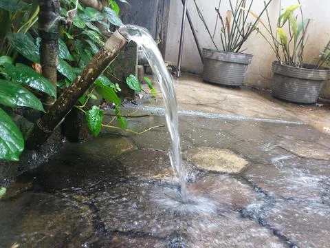 A stream of water flowing from a pipe. Stock Photos