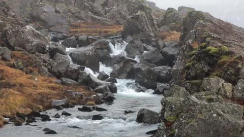 A stream of water flows between large rocks Stock Footage 305873794