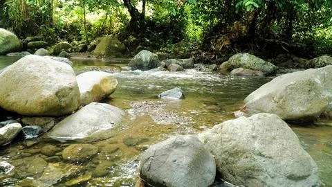 A stream of water flows between large rocks Stock Photos