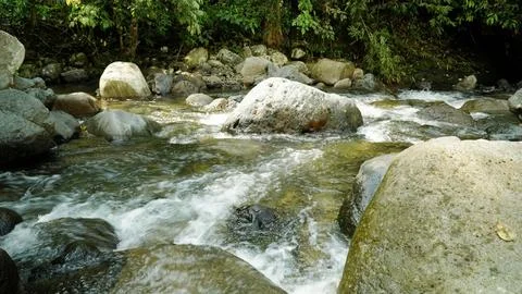 A stream of water flows between large rocks Stock Photos