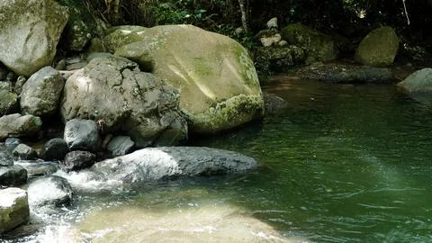 A stream of water flows between large rocks Stock Photos