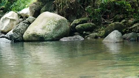 A stream of water flows between large rocks Stock Photos