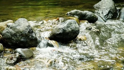 A stream of water flows between large rocks Stock-Fotos