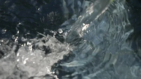 A stream of water flows into a container and boils. A stream of clean water.. Stock Footage 337768215
