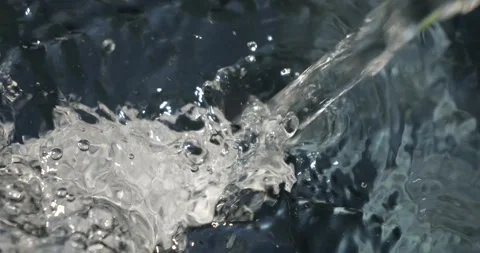 A stream of water flows into a container and boils. A stream of clean water.. Stock Footage 337769036