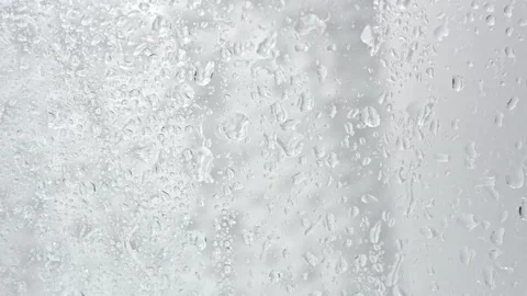 A stream of water flows down glass with drops Stock Footage 252195698