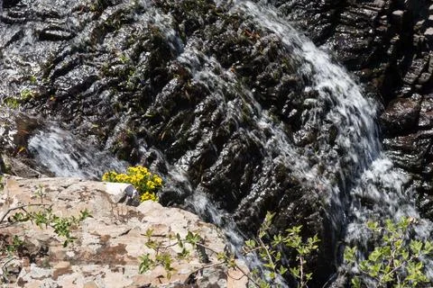 A stream of water flows down a rocky hillside Foto stock