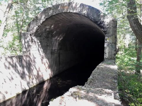 A stream of water flows from an old underground bunker Stock Photos