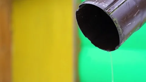 A stream of water flows out of a drainpipe against a yellow wall Stock Footage 124918281