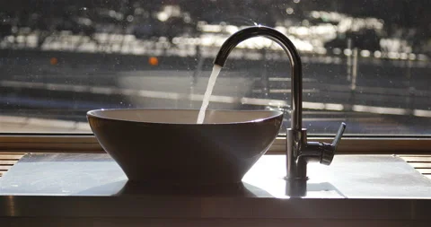 A stream of water flows from the tap into the sink Stock Footage 139587053