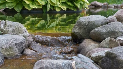 Stream of water flows through the rocks. Small pond water falls. Stock Footage 116060382