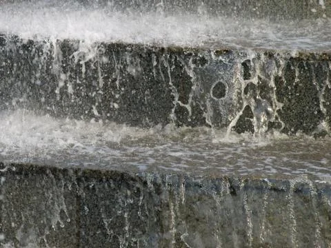 The stream of water on the granite steps.background. Stock Photos