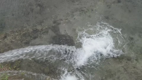 Stream of water merges into river Video stock 334856519