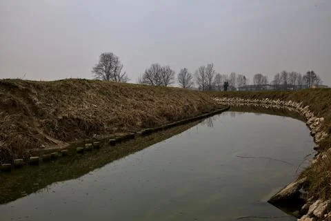 Stream of water next to the fields in the italian countryside in winter on a  Stock Photos