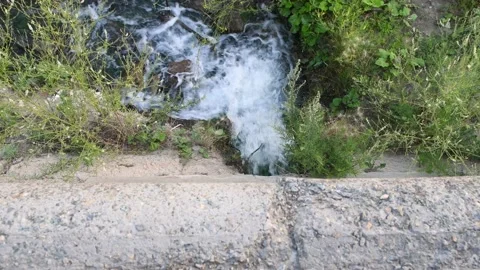Stream of water from a pipe, top view. Polluted sewage water Stock Footage 157671374