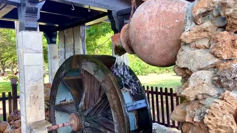 A stream of water pours onto the wheel. Beautifully designed fountain. Stock-Footage 252171128