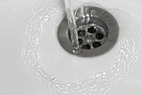 Stream of water running down the drain Stockfoto's
